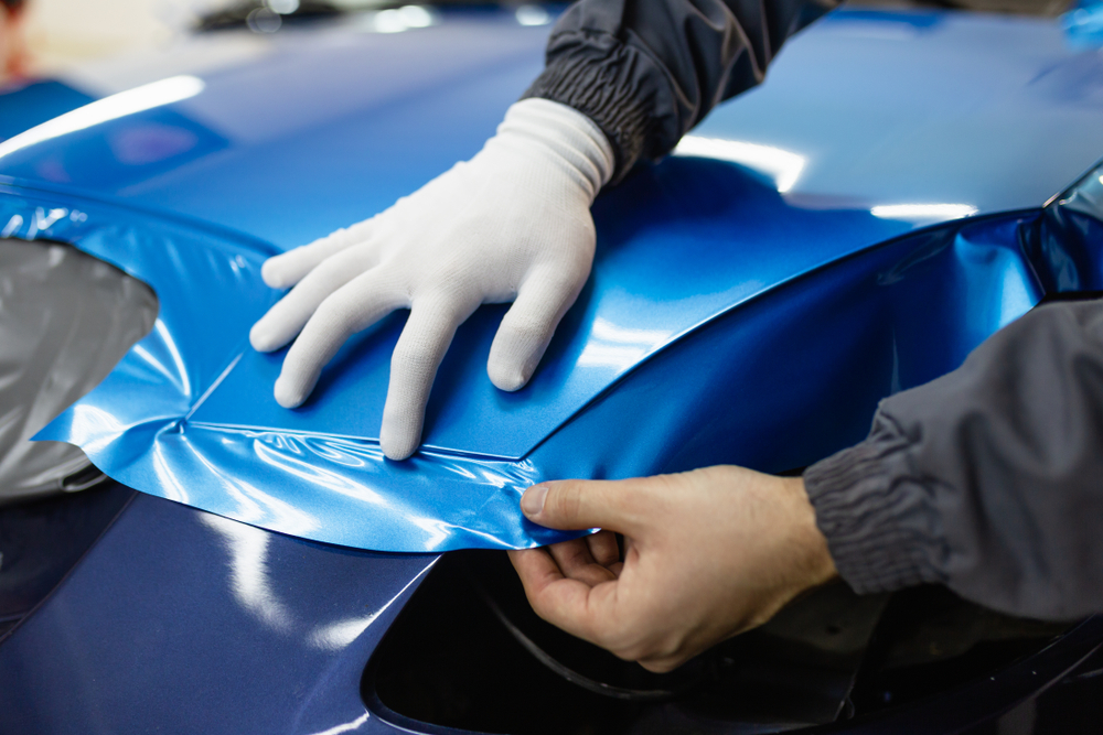 Car wrapping specialist putting vinyl foil