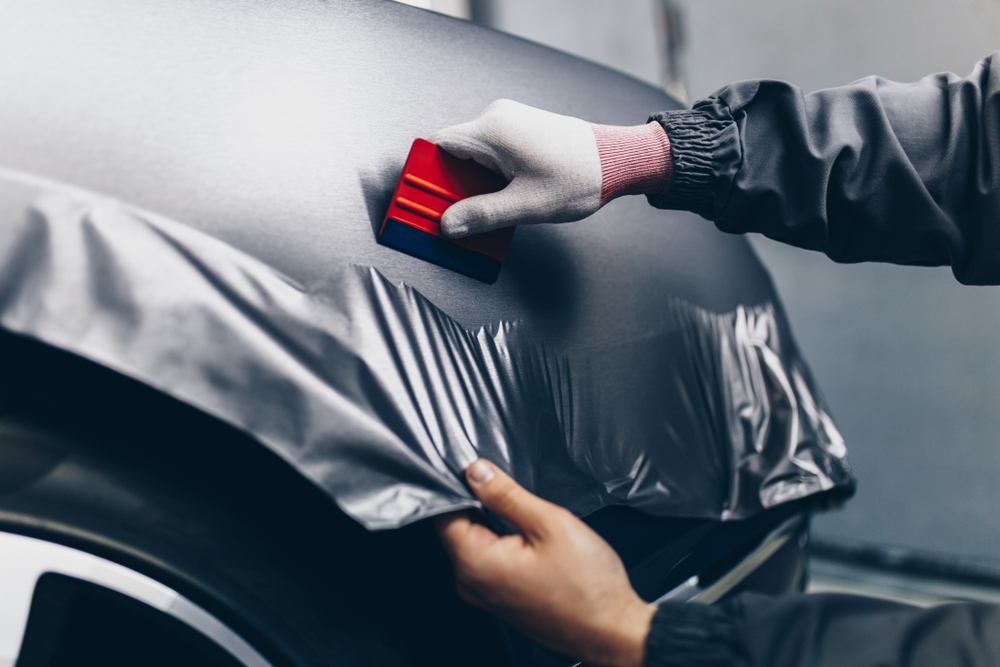 Vinyl wrapping specialist putting a wrap on a car